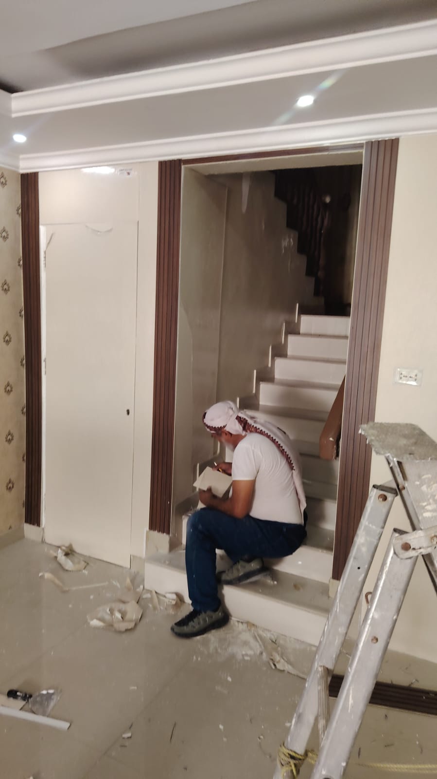 فني تركيب يركب شرائح بديل الخشب وتكسيات الباب المخفي